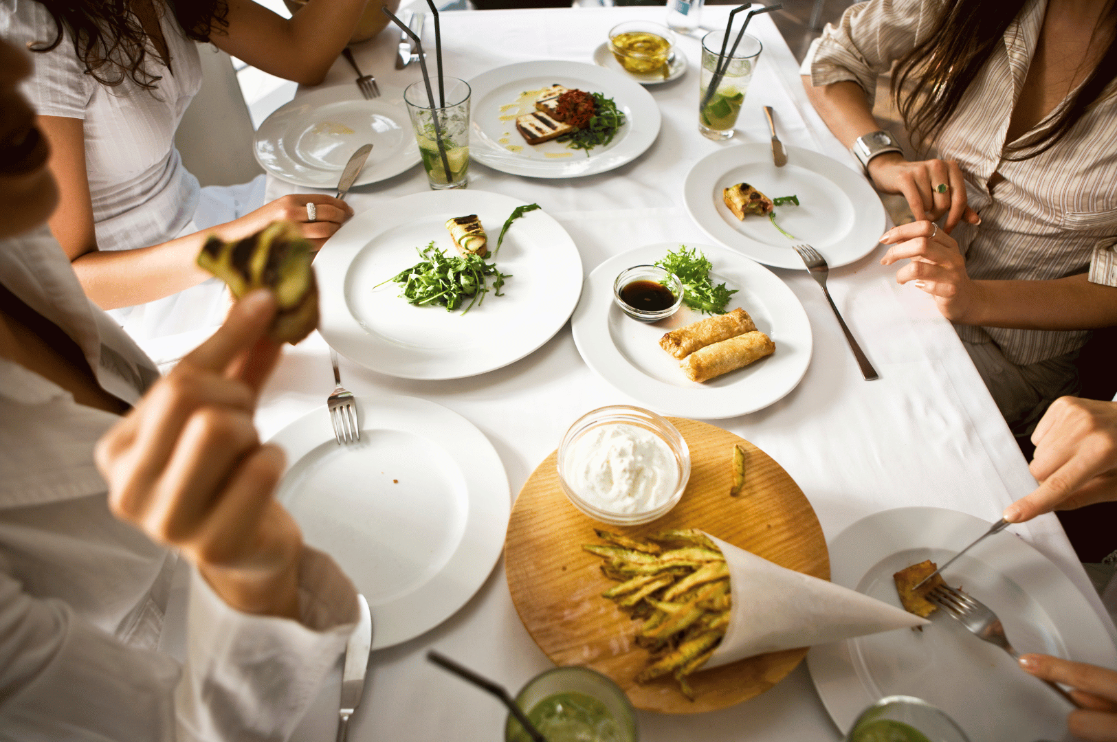 Communal-Dining- (4) A group sharing a meal around a table, passing dishes and enjoying conversation, reflecting communal dining traditions.