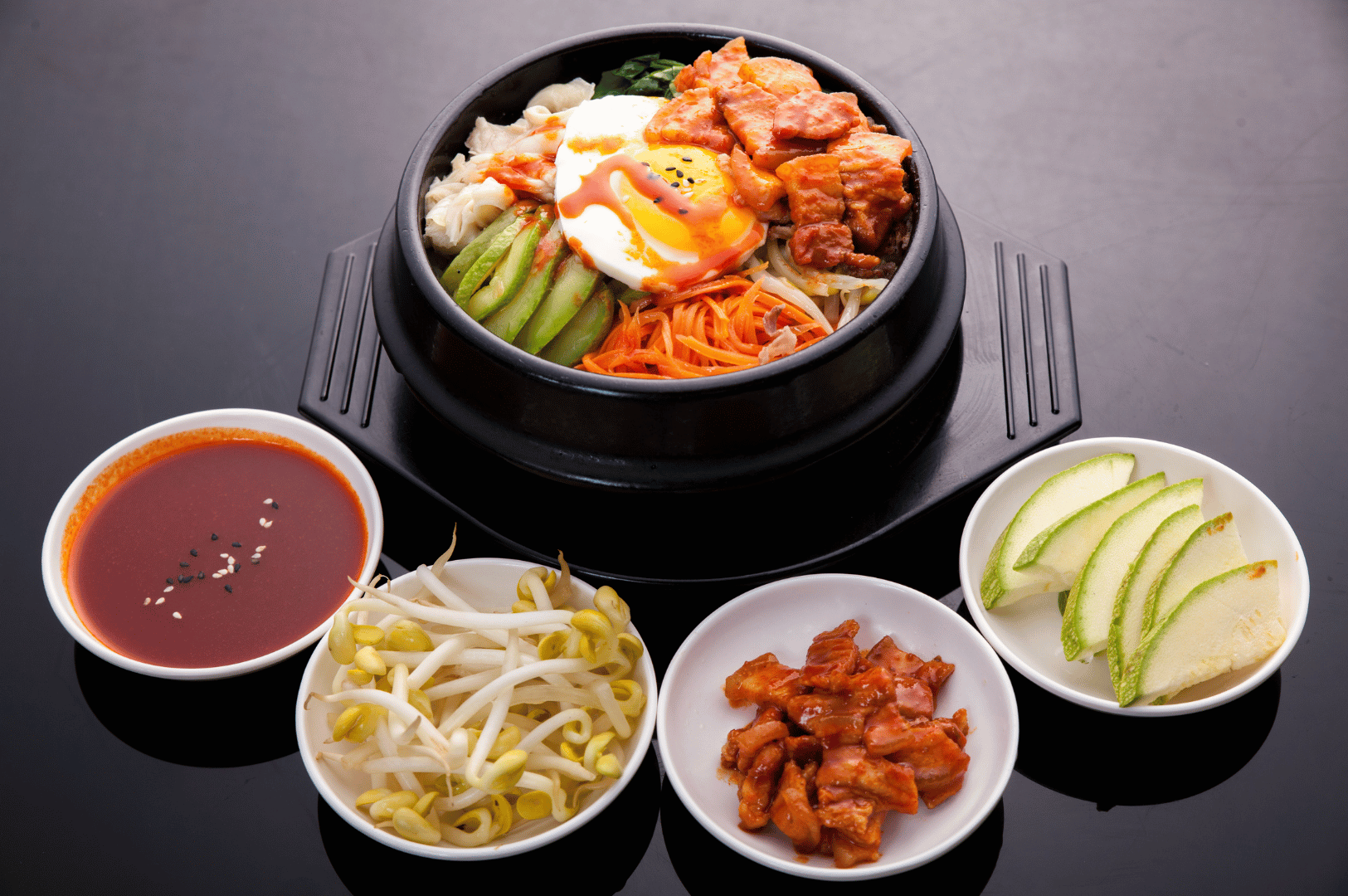 Jeonju- (3) Overhead shot of a vibrant bowl of bibimbap with colorful vegetables, marinated beef, and a raw egg yolk in the center, highlighting Jeonju-style presentation