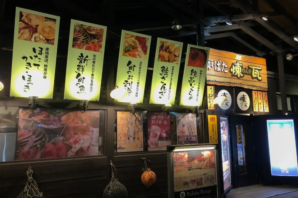 Illuminated outdoor signage and menu banners for Robata Renga, a famous robatayaki (charcoal grill) restaurant in Kushiro, Hokkaido.