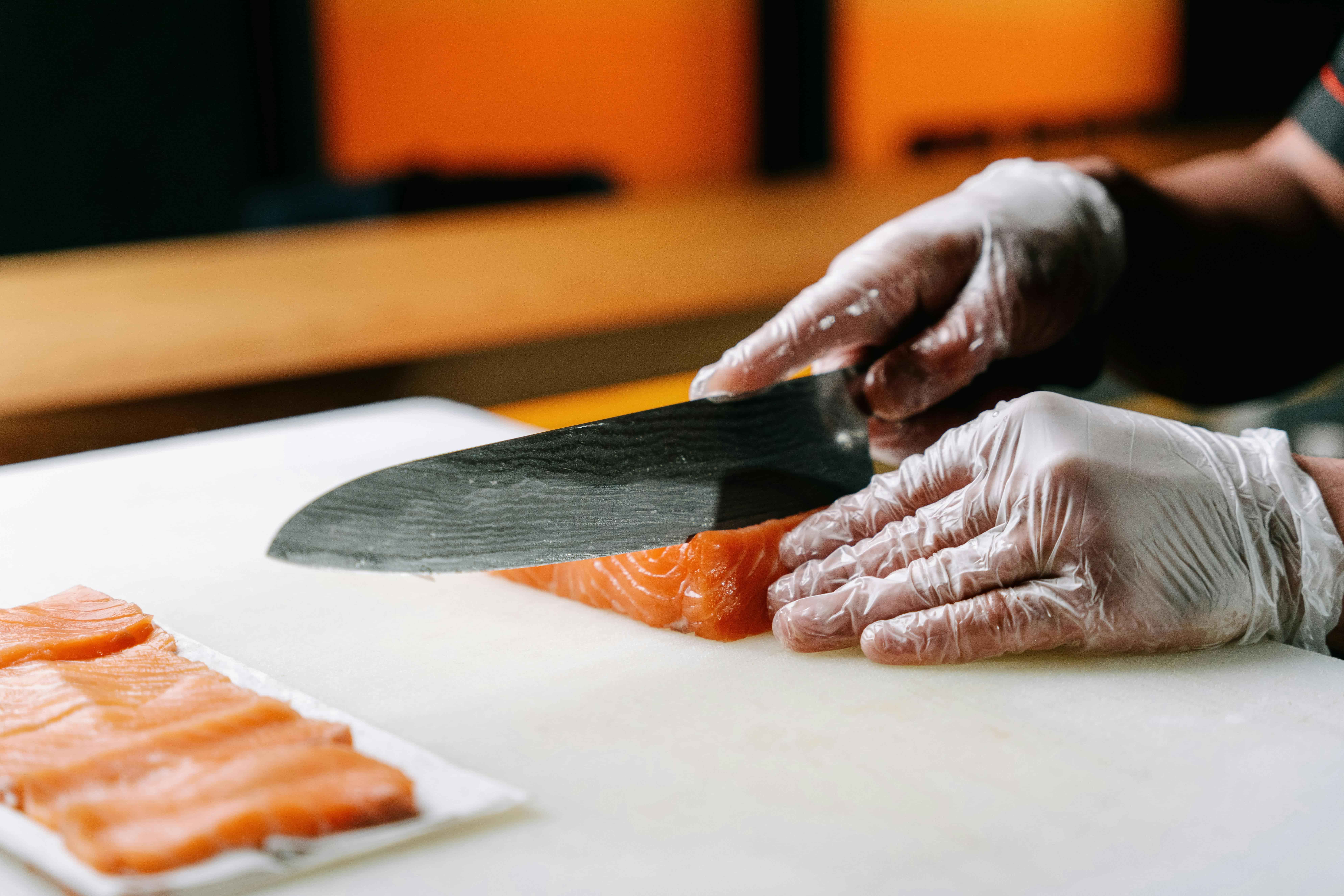 Food In Japan - 6 A chef precisely cutting salmon, showcasing its attention to detail.
