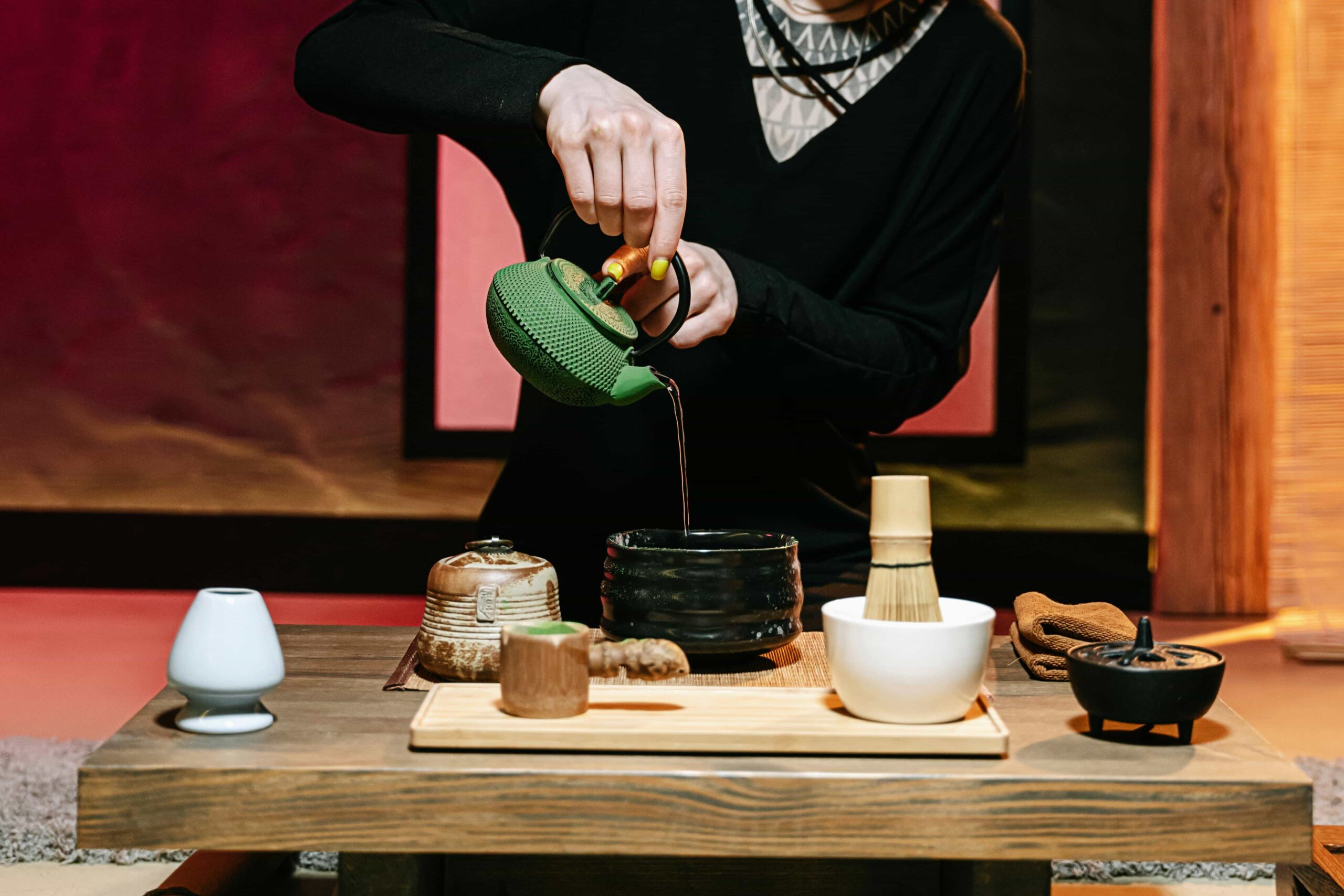 Food In Japan - 7 A photo of a woman preparing tea with all its traditional tools for a proper tea ceremony.