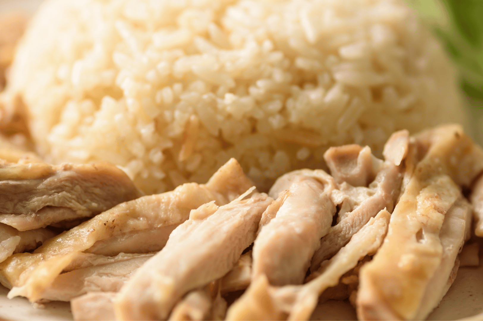 Close-up of tender poached chicken and fluffy white rice—essential elements of Singapore’s iconic Hainanese chicken rice, featured in The Ultimate Hainanese Chicken Rice Recipe: A Deep Dive.