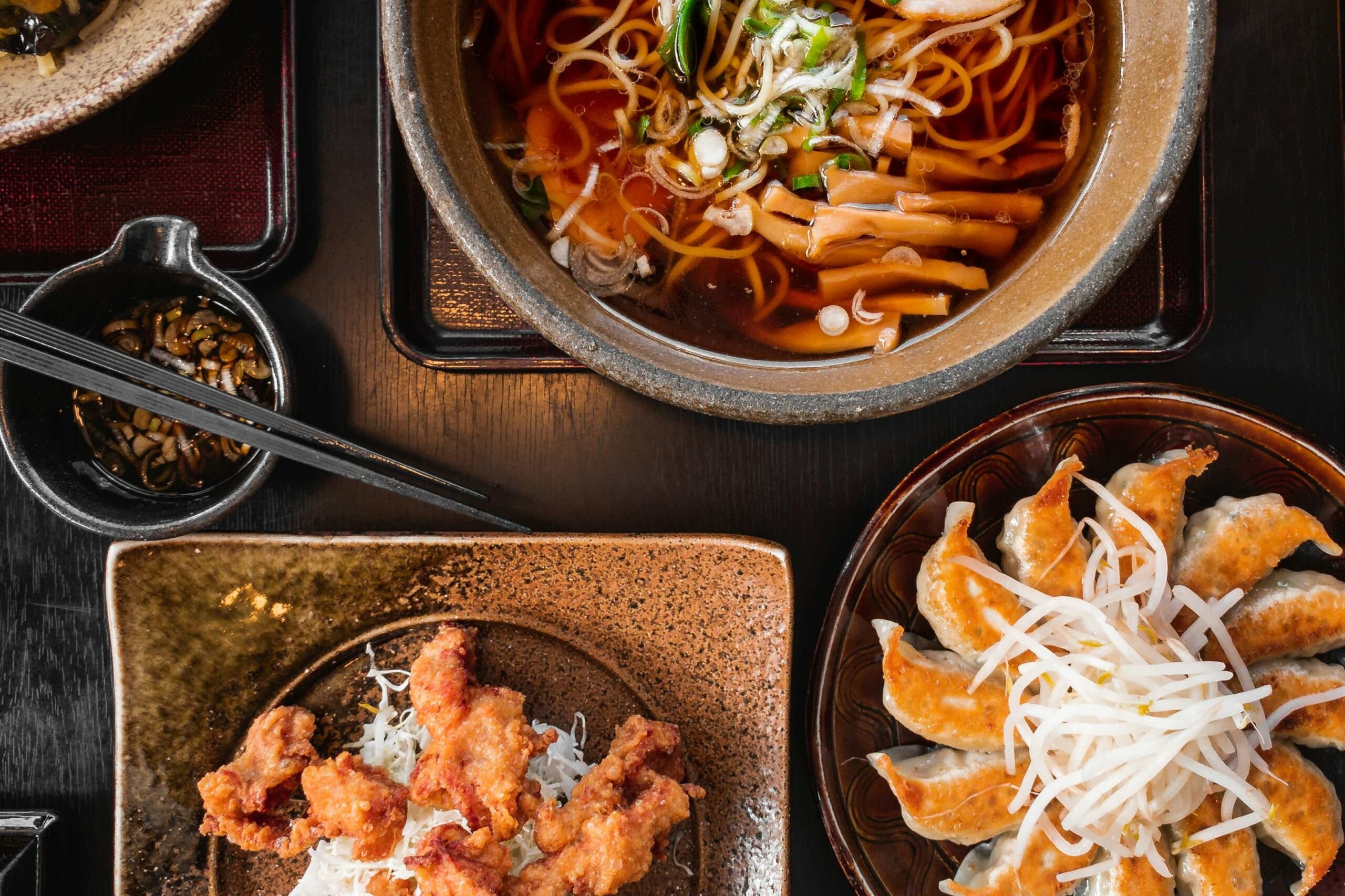 Japanese food in Japan - 2 A top view of multiple authentic Japanese culinary delicacies laid out on a wooden table.