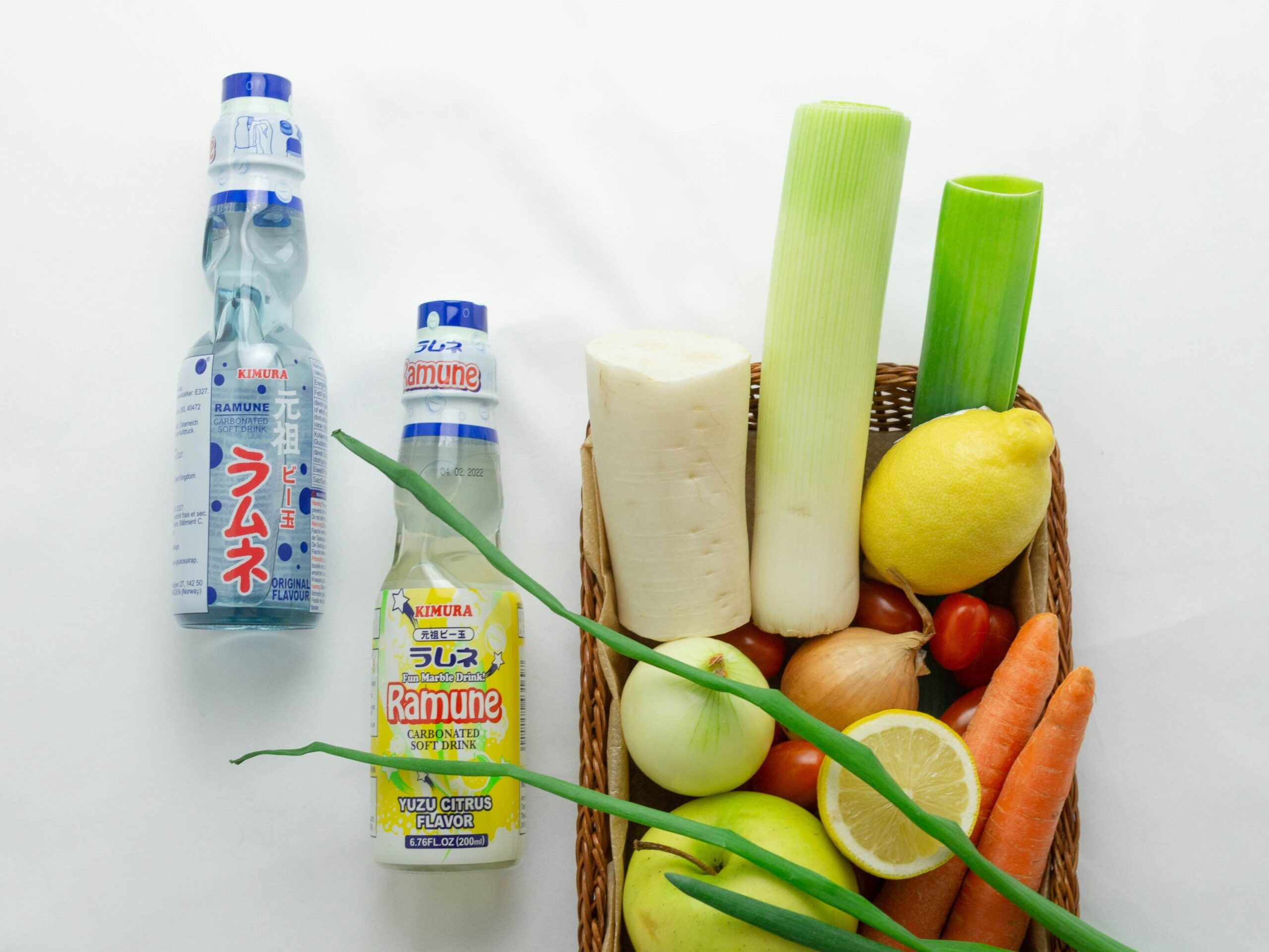 Ramune Marble Soda - 7 Ramune bottles accompanied by various fruits and vegetables, similar to their flavors.