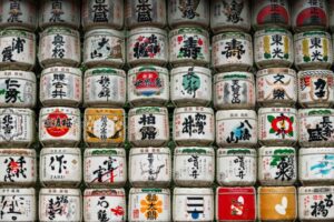 A wall of Japanese sake barrels stacked, showcasing a beautiful collection of imagery if sake.