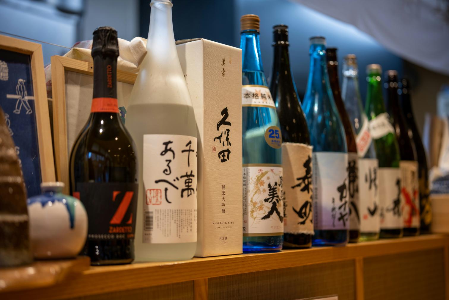 Rice WIne - 4 A countertop filled with different kinds of sake from light to strong, from vintage to recent.