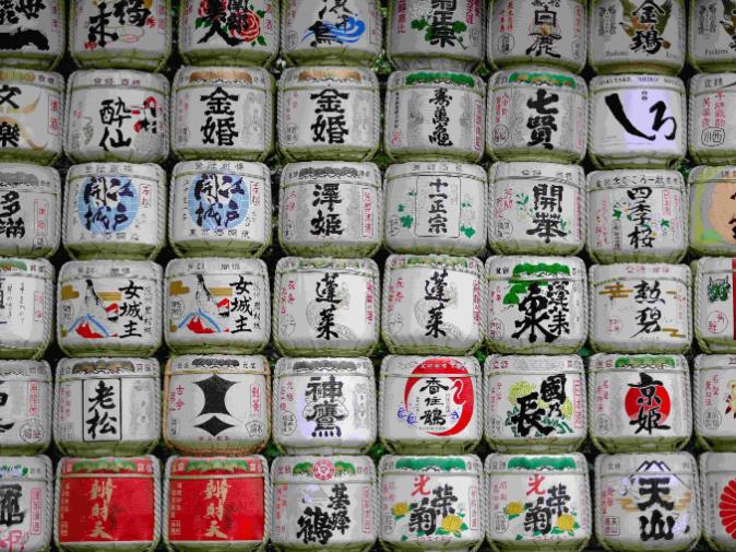 Understanding Sake - 3 A photo of a wall of sake barrels, displaying its unique style as it towers over onlookers.
