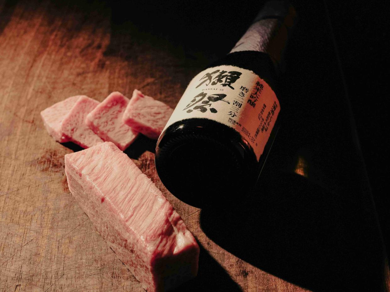 Understanding Sake - 6 An example of a strong sake sitting on a wooden table, accompanied by delicacy that is best paired with.