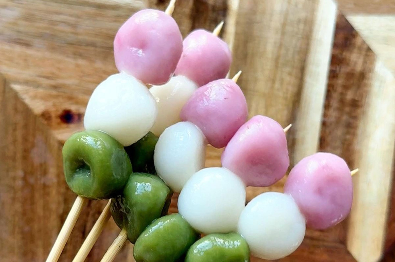 Close-up of Hanami Dango skewers featuring traditional pink, white, and green sweet mochi balls.