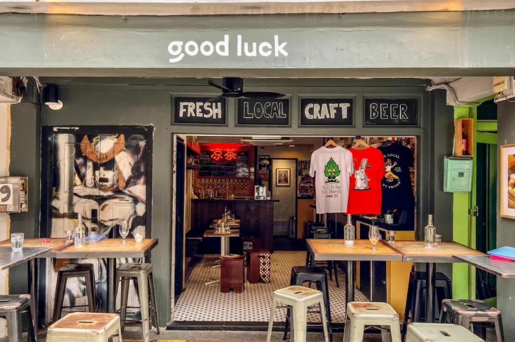 The front of Good Luck Beerhouse, a traditional Singaporean shophouse style bar with outdoor metal stools and "Fresh Local Craft Beer" signage.