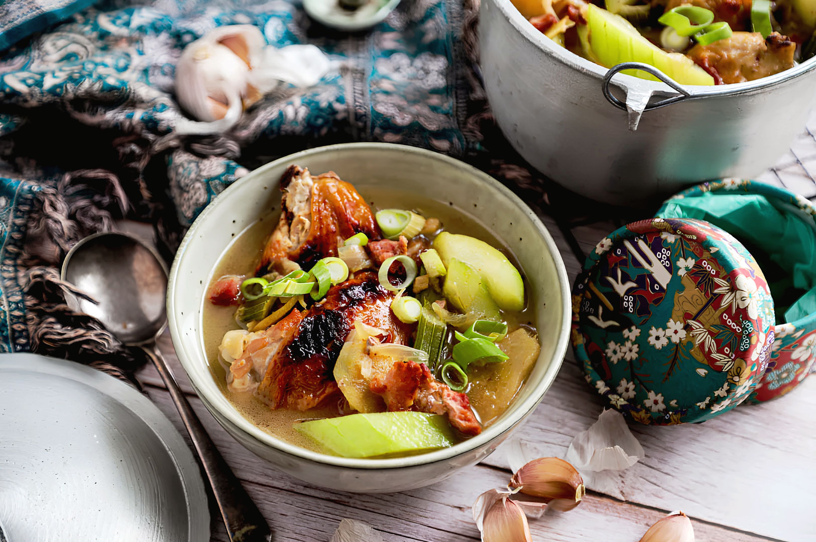 Authentic Benguet pinikpikan chicken soup with smoky broth, vegetables, and spring onions served in a rustic bowl in the Cordillera region of the Philippines