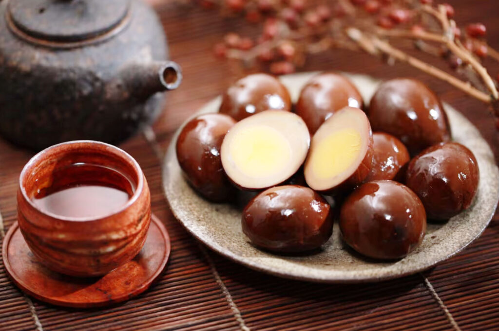 Traditional Taiwanese iron eggs (tie dan) braised in soy sauce served on a ceramic plate with tea, showcasing Taiwan’s iconic preserved street food snack.