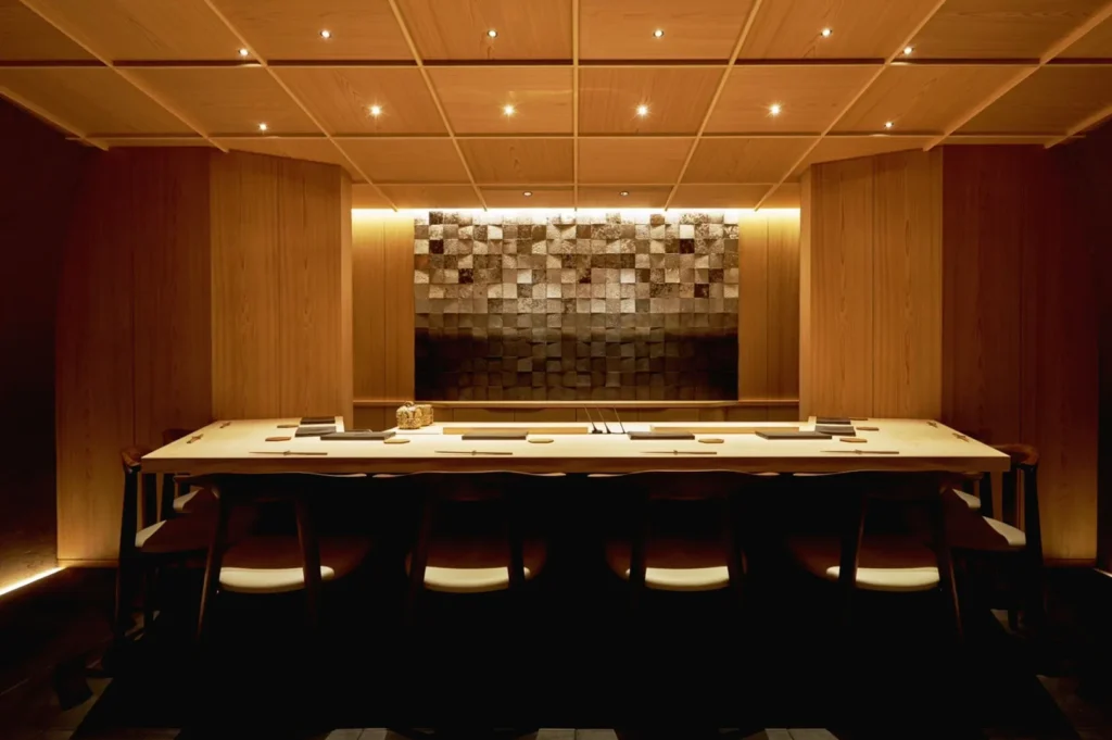 Luxury omakase dining room in Singapore with warm lighting, Japanese design and exclusive counter seating