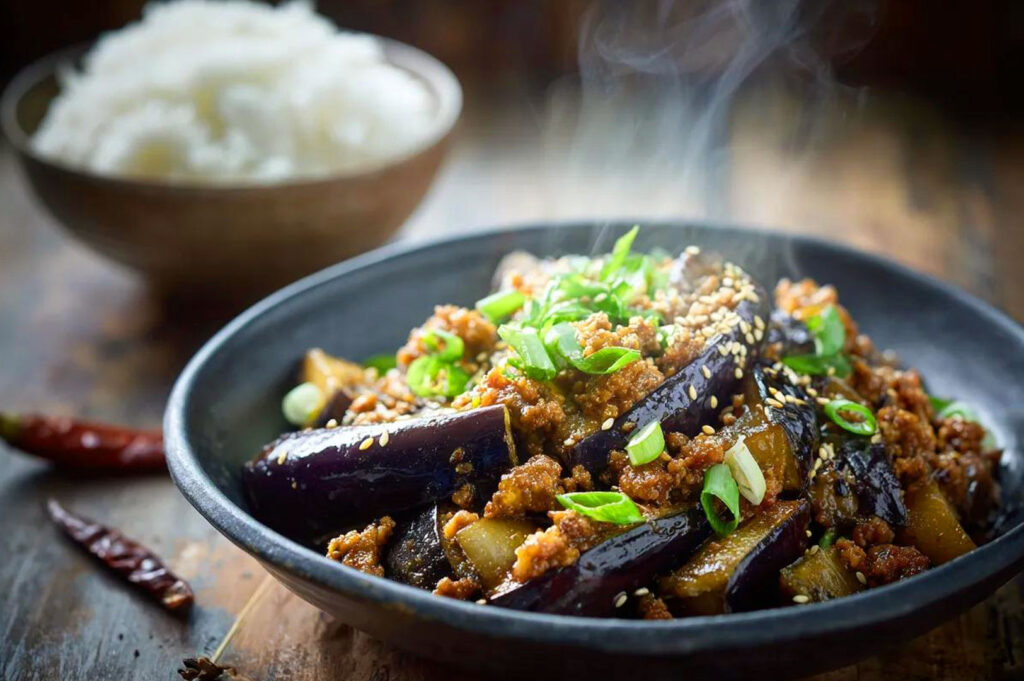 Chinese eggplant rice bowl with glossy garlic soy sauce and sesame over steamed white rice