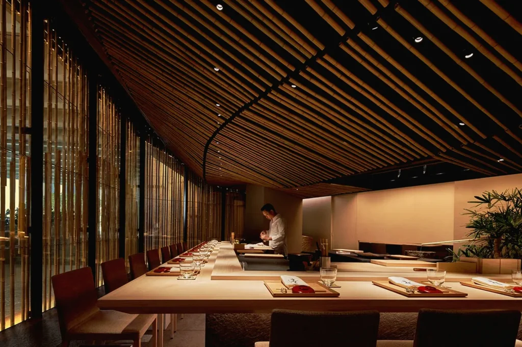 Elegant omakase sushi counter in Singapore with minimalist Japanese interior and chef preparing seasonal dishes
