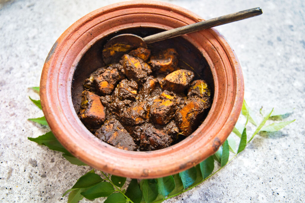 Authentic Sri Lankan Ambul Thiyal with blackened tuna coated in goraka spice paste served in a clay pot.