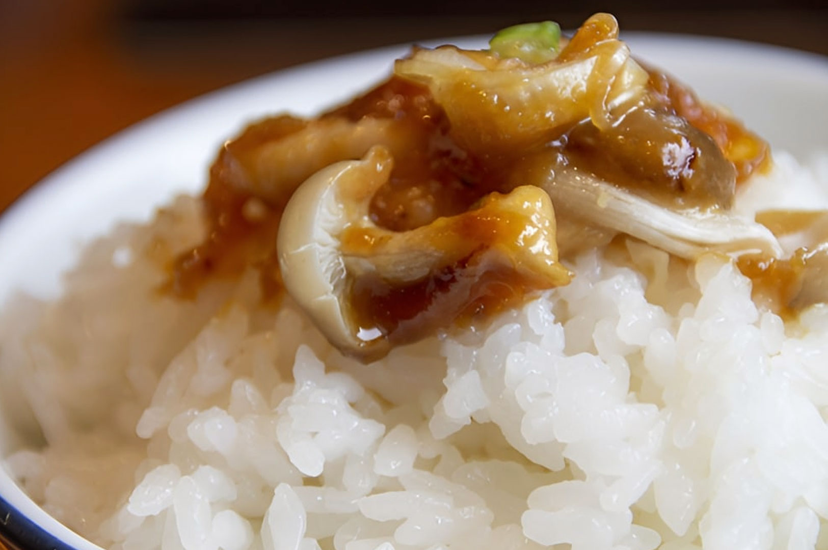 Steamed white rice topped with warm hoba miso and mushrooms in close-up