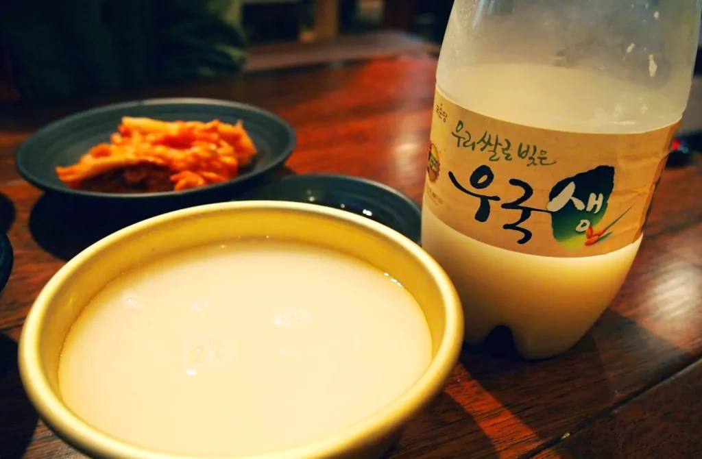 A bottle of Korean Wine and a Makgeolli Bowls in a wooden table.