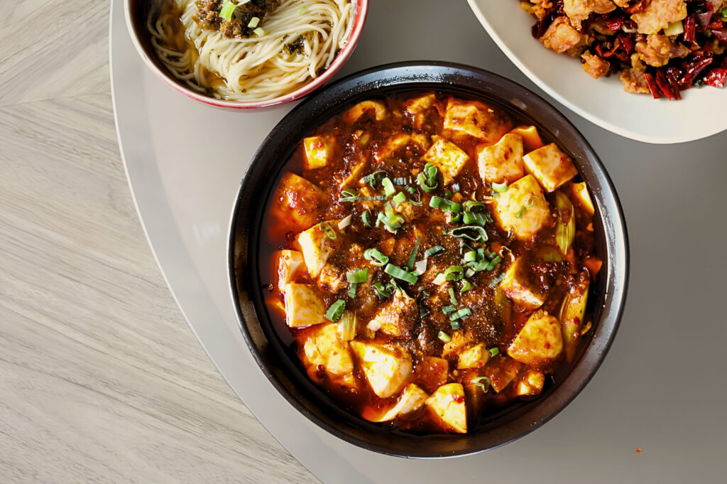 Spicy mapo tofu served at Si Chuan Dou Hua Restaurant Singapore with handmade noodles and Sichuan-style stir-fried dishes on modern Chinese dining table