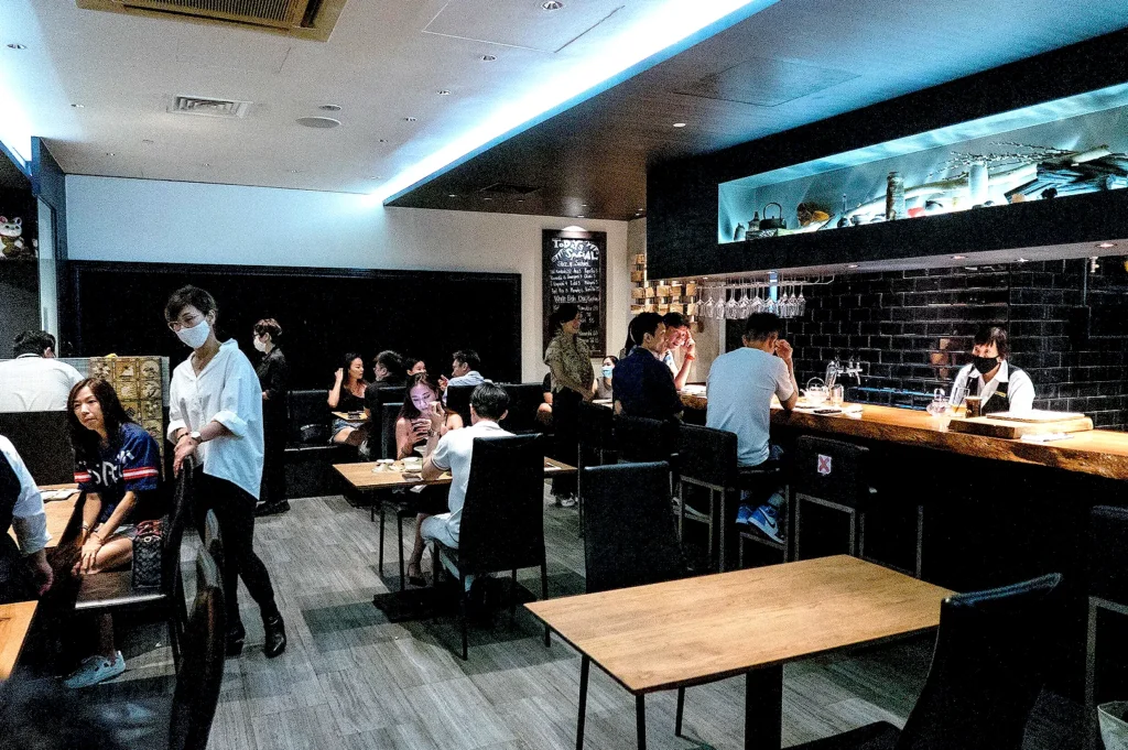 Modern Japanese restaurant interior at Kazu Sumiyaki Restaurant Singapore with cozy dining tables, bar seating, and contemporary décor.