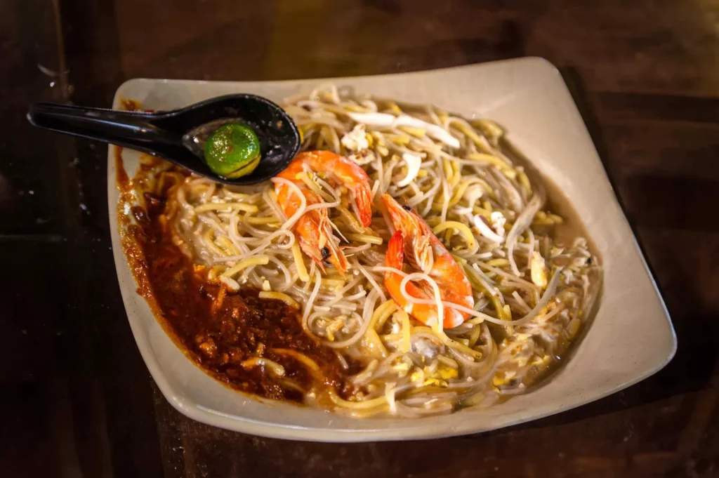 Singapore Hokkien mee with prawns, sambal chilli and calamansi lime served on a plate