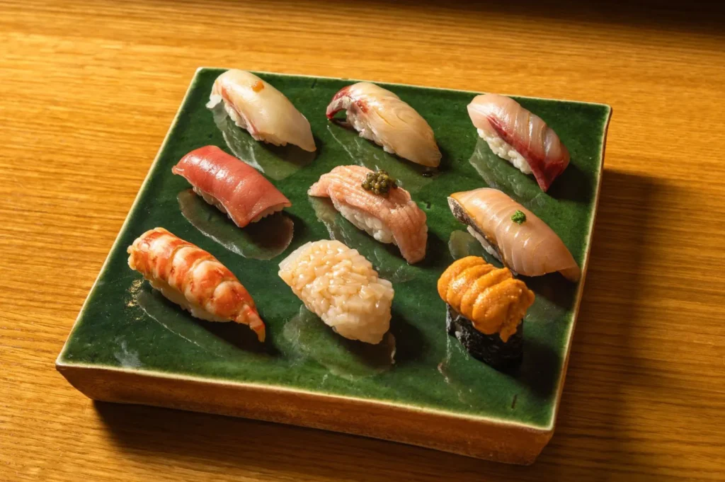 Premium assorted nigiri sushi platter featuring fresh tuna, shrimp, salmon, and uni on a ceramic plate