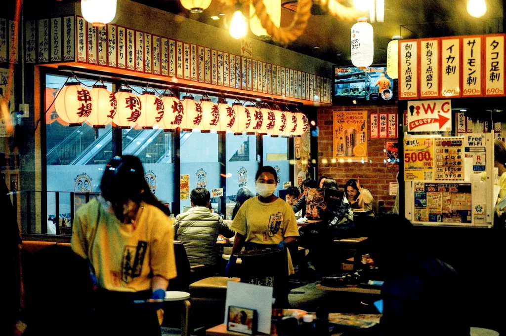 Traditional Japanese izakaya exterior at Izakaya Nijumaru Singapore with lanterns, menu boards, and lively evening dining atmosphere.