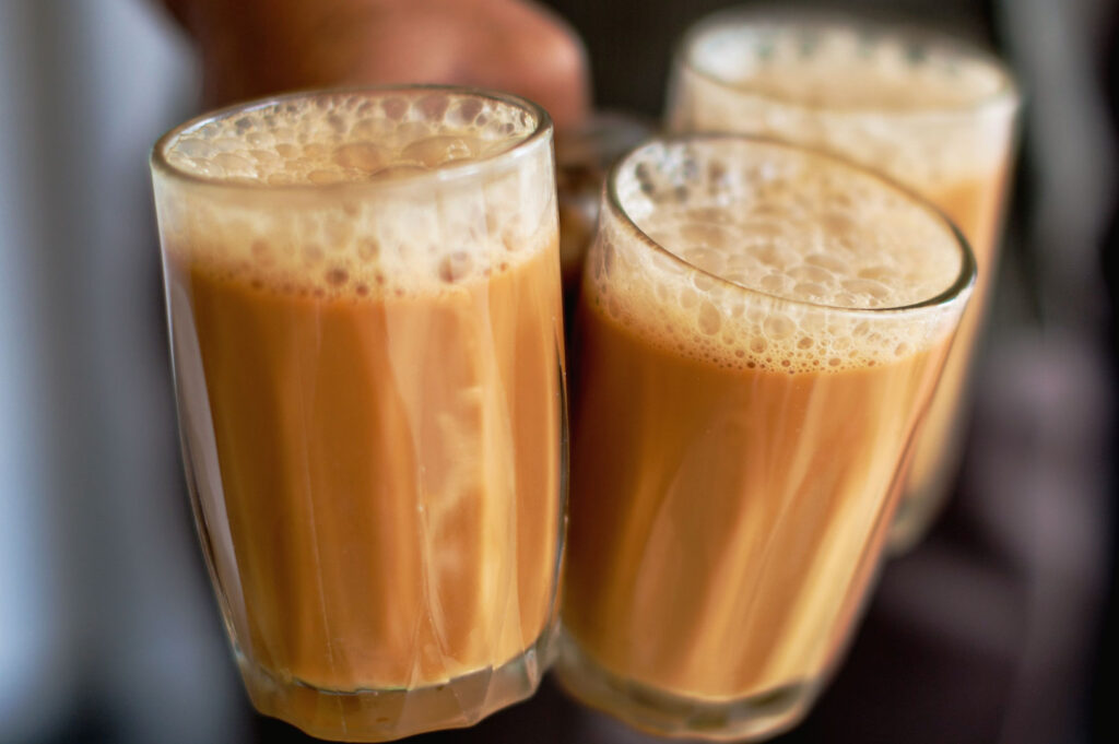 Traditional Malaysian teh tarik served in glass cups with a frothy milk tea foam topping.
