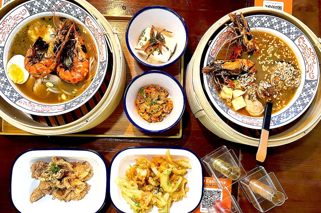 Signature prawn ramen meal at Ebi Bar Singapore with grilled prawns, rich seafood broth, tofu, and crispy side dishes.