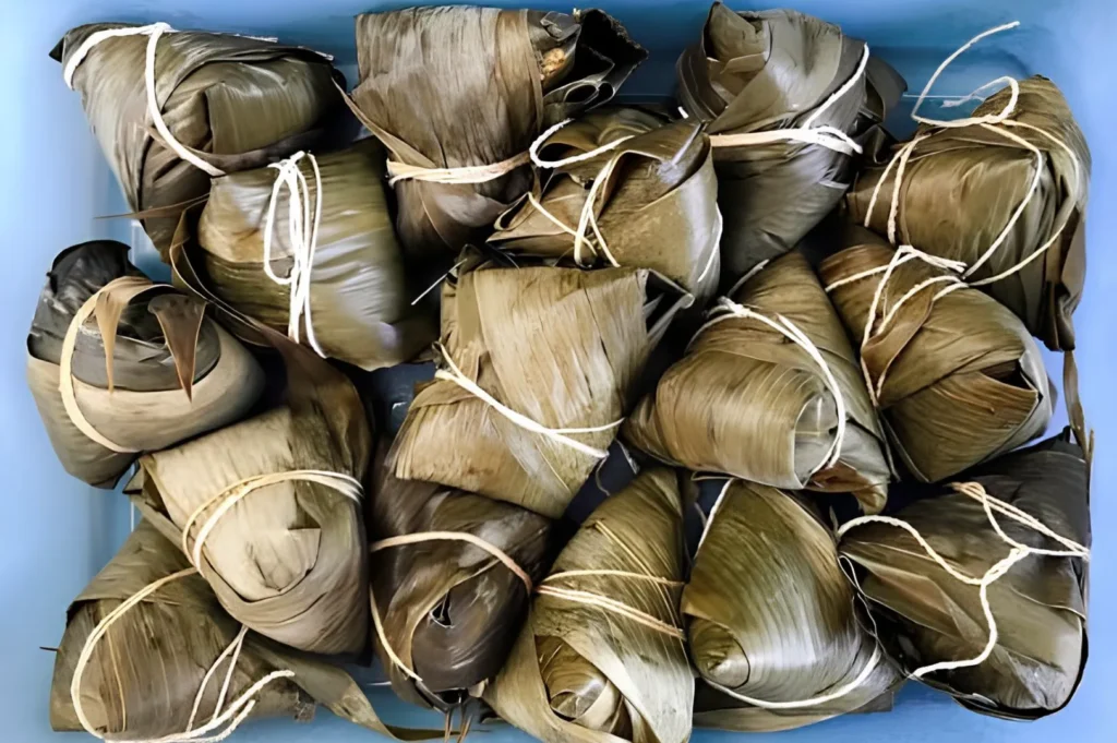 Traditional banana leaf wrapped rice parcels tied with natural string.