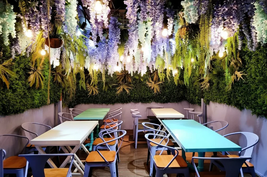 Co Hai Banh Mi Singapore interior featuring a garden-inspired dining space with hanging flowers and cozy Vietnamese café ambiance.
