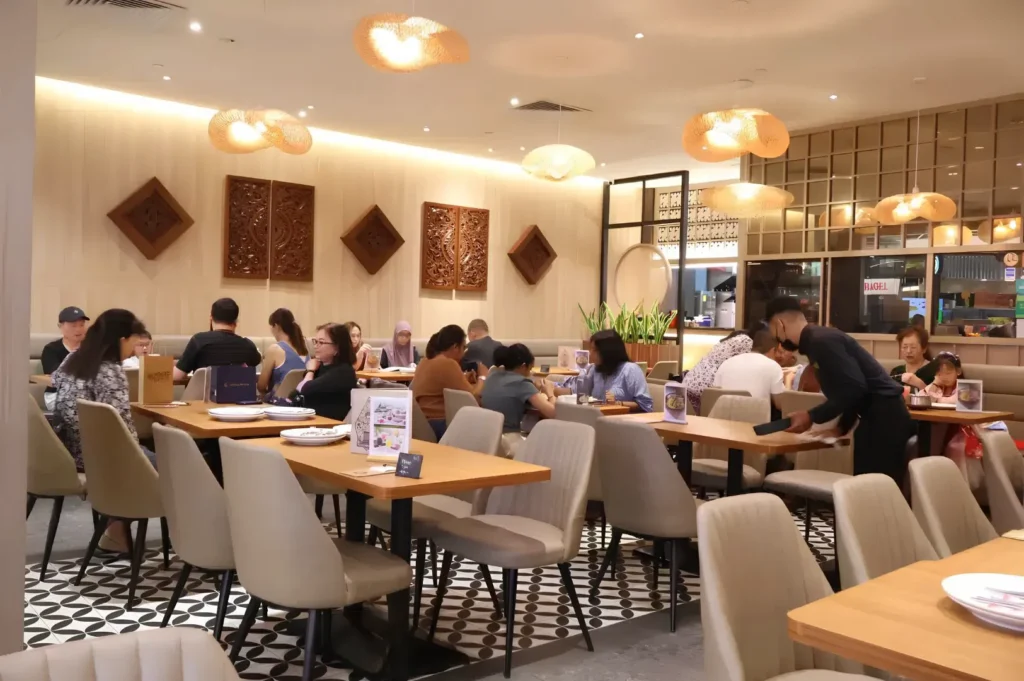 Modern Indonesian restaurant interior with warm lighting and spacious seating.
