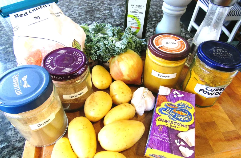 Fresh ingredients for homemade Indian potato curry with potatoes, spices, garlic, lentils, and onion