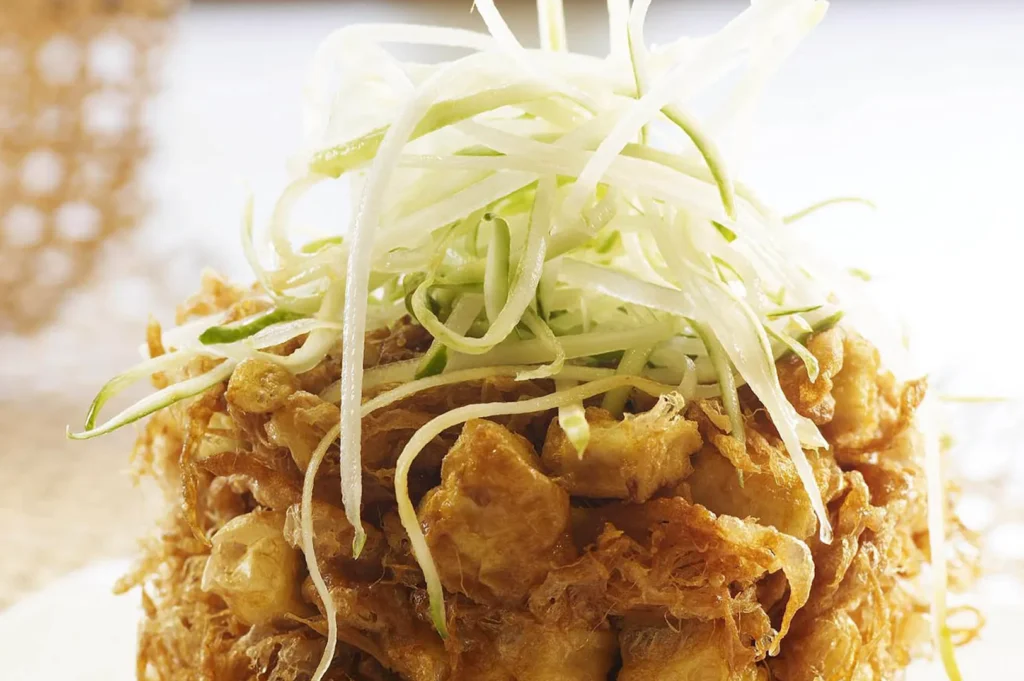 Crispy Indonesian tofu topped with shredded cucumber and savory seasoning.