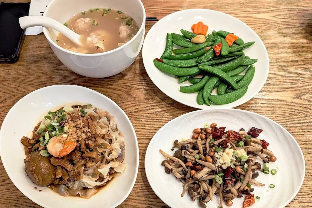 Traditional Taiwanese meal at Isshin Machi East Coast featuring dry noodles, pork ball soup, stir-fried vegetables, and mushrooms in Singapore.