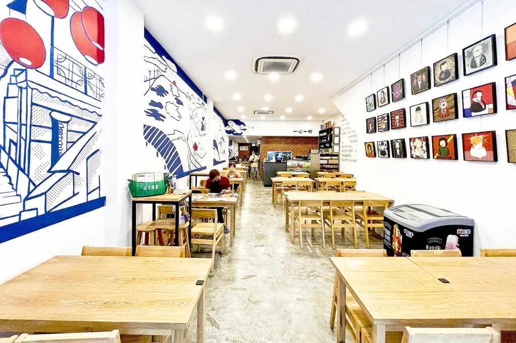 Spacious dining room at Isshin Machi East Coast in Singapore with contemporary Taiwanese-inspired artwork, wooden tables, and bright minimalist interior.