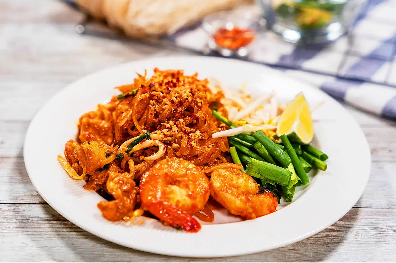 Classic Pad Thai with stir-fried rice noodles, prawns, bean sprouts, chives, crushed peanuts and lime wedge