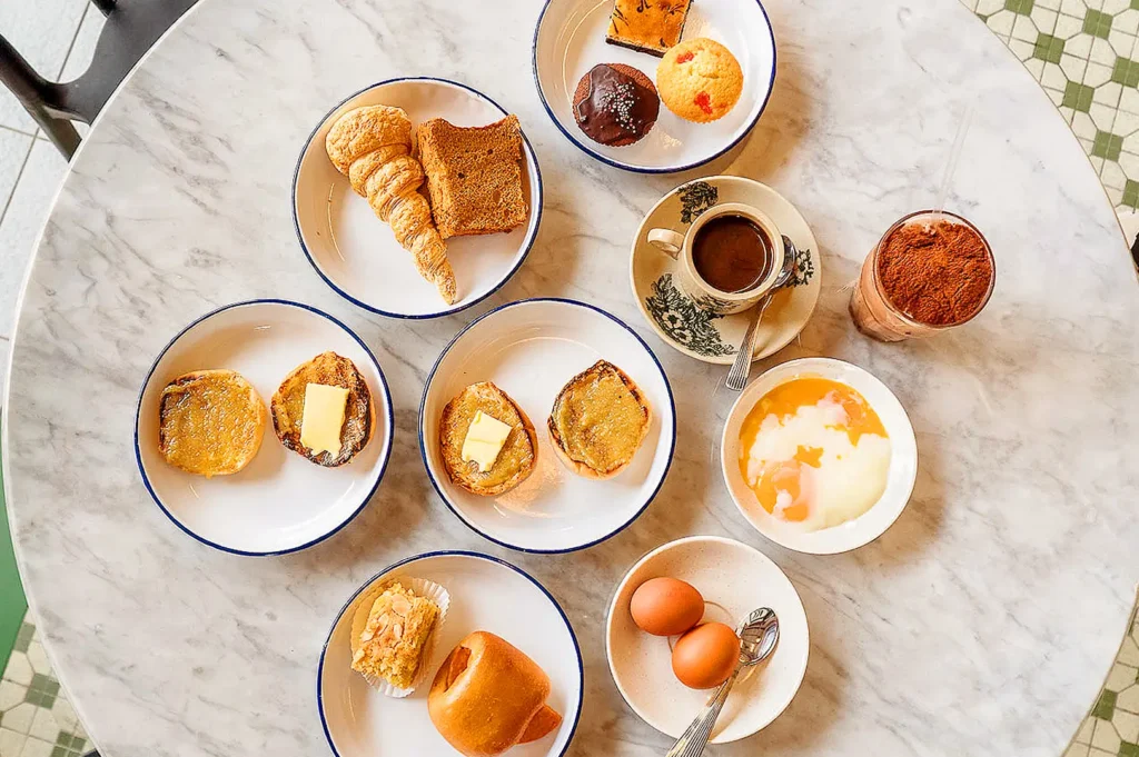Traditional Singaporean breakfast spread with kaya buns, toast, soft-boiled eggs, pastries and coffee at Chin Mee Chin Confectionery