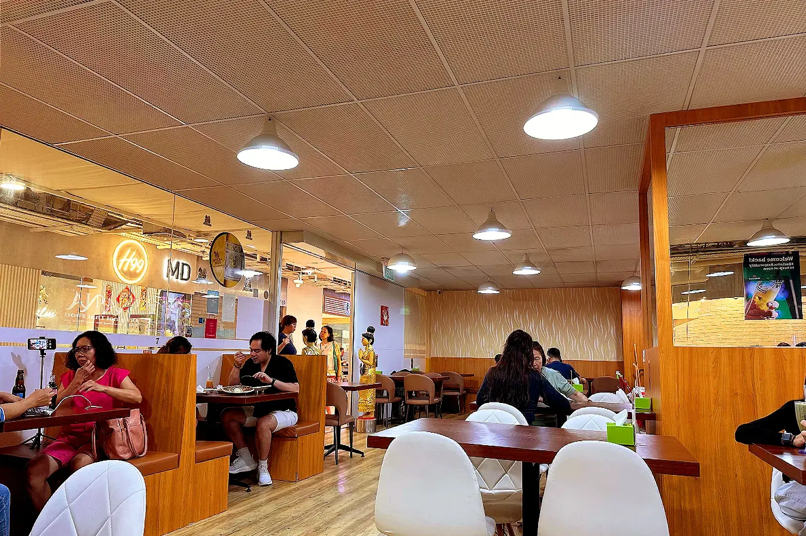 Nana Original Thai Food restaurant dining area with wooden tables, booth seating and warm Thai-inspired interior design