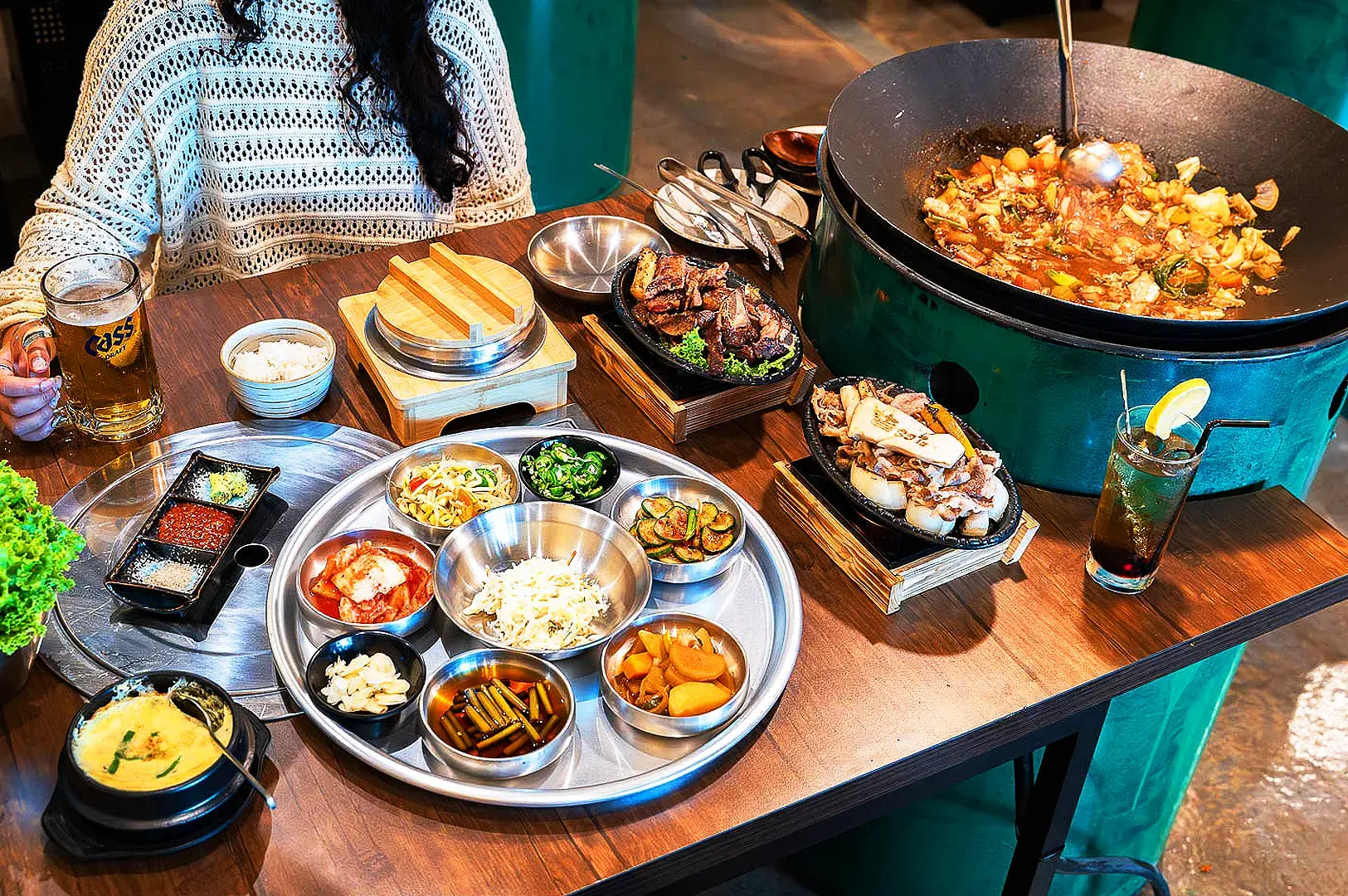 Korean restaurant table with grilled meat, kimchi, banchan, rice and traditional Korean dishes