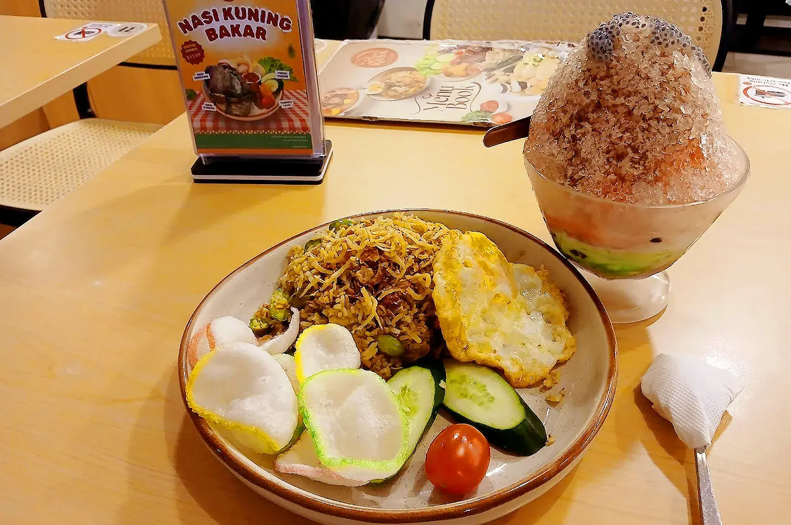 Indo Rasa Singapore nasi goreng meal with fried egg, crispy anchovies, crackers, cucumber and shaved ice dessert