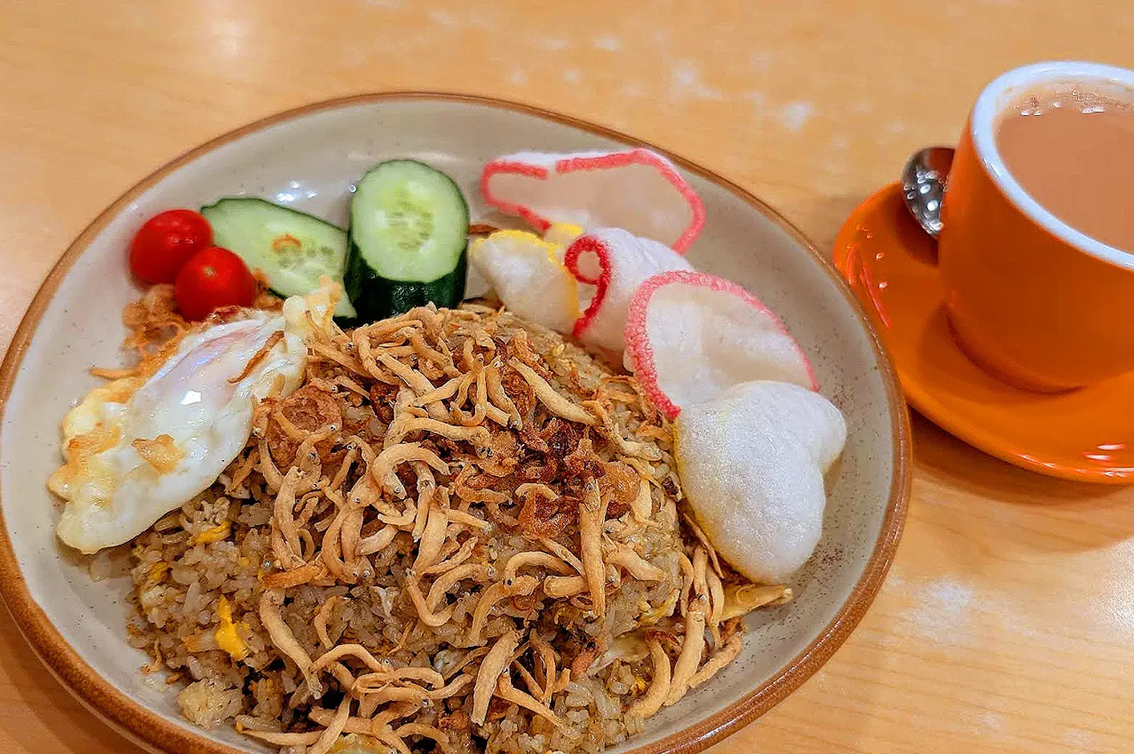 Indonesian nasi goreng with crispy anchovies, fried egg, cucumber, tomatoes and crackers at Indo Rasa Singapore