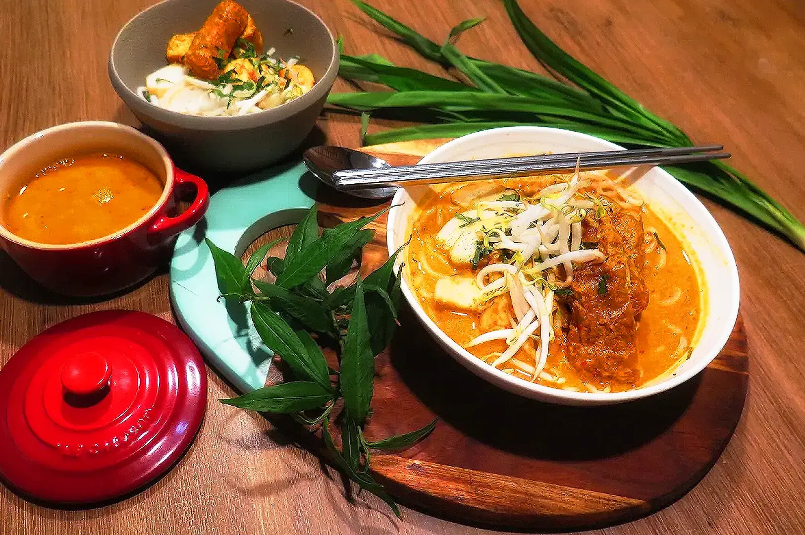 Authentic vegetarian laksa served with rich coconut curry soup, rice noodles, tofu puffs, bean sprouts, laksa leaves, and homemade rempah paste