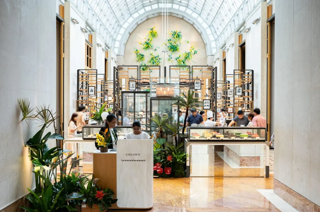 Colony restaurant Singapore entrance with elegant dining space, floral displays and contemporary interior design