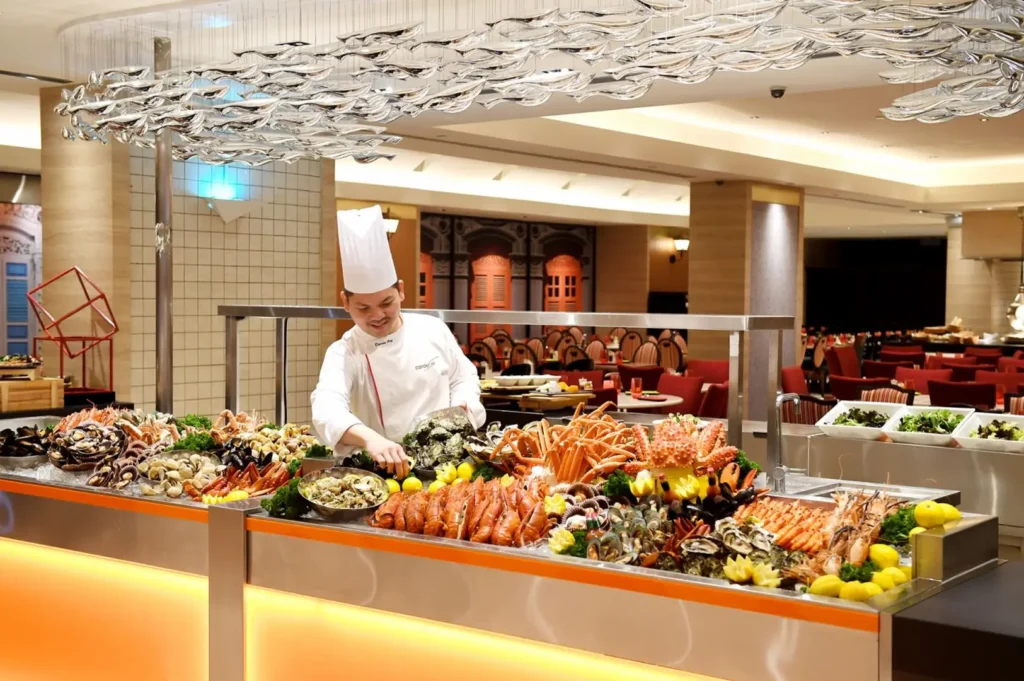 Carousel restaurant Singapore seafood buffet with chef preparing fresh shellfish and seafood at the ice counter