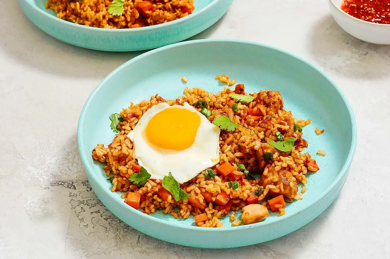 Sambal fried rice with fried egg, chicken, carrots, spring onion and fresh coriander