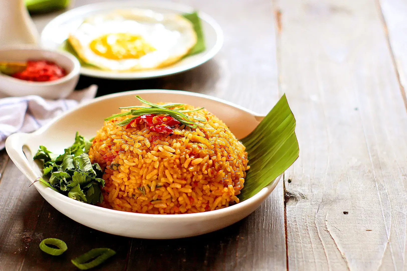 Spicy sambal fried rice with fried egg, cucumber, tomatoes, lime and crispy fried shallots