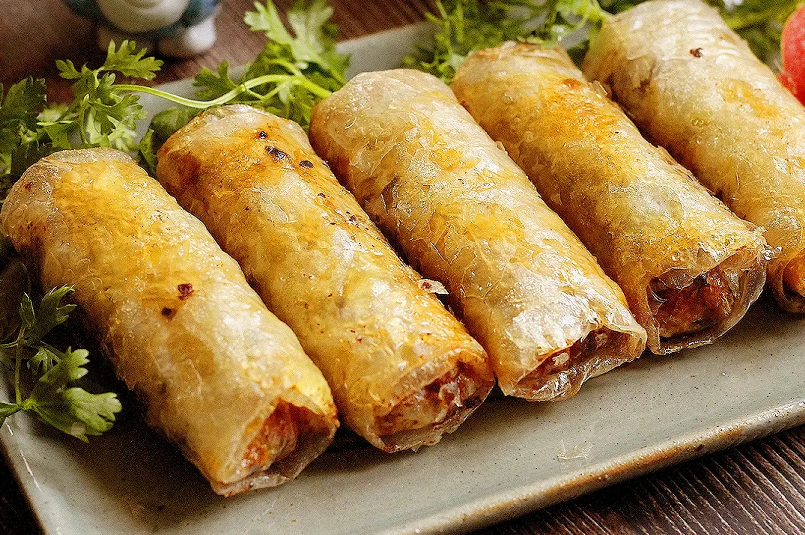 Vietnamese spring rolls with fresh herbs and savory filling served on a plate