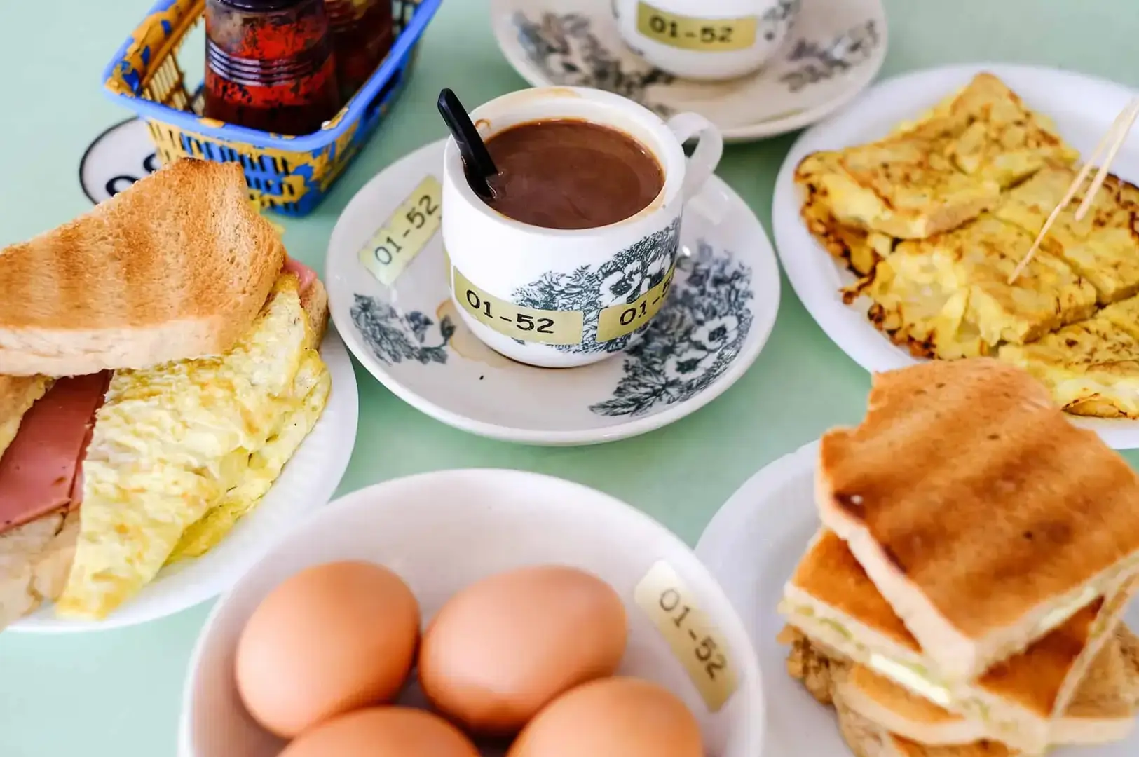 Singapore Chinatown breakfast spread with kaya toast, eggs, coffee and traditional local dishes