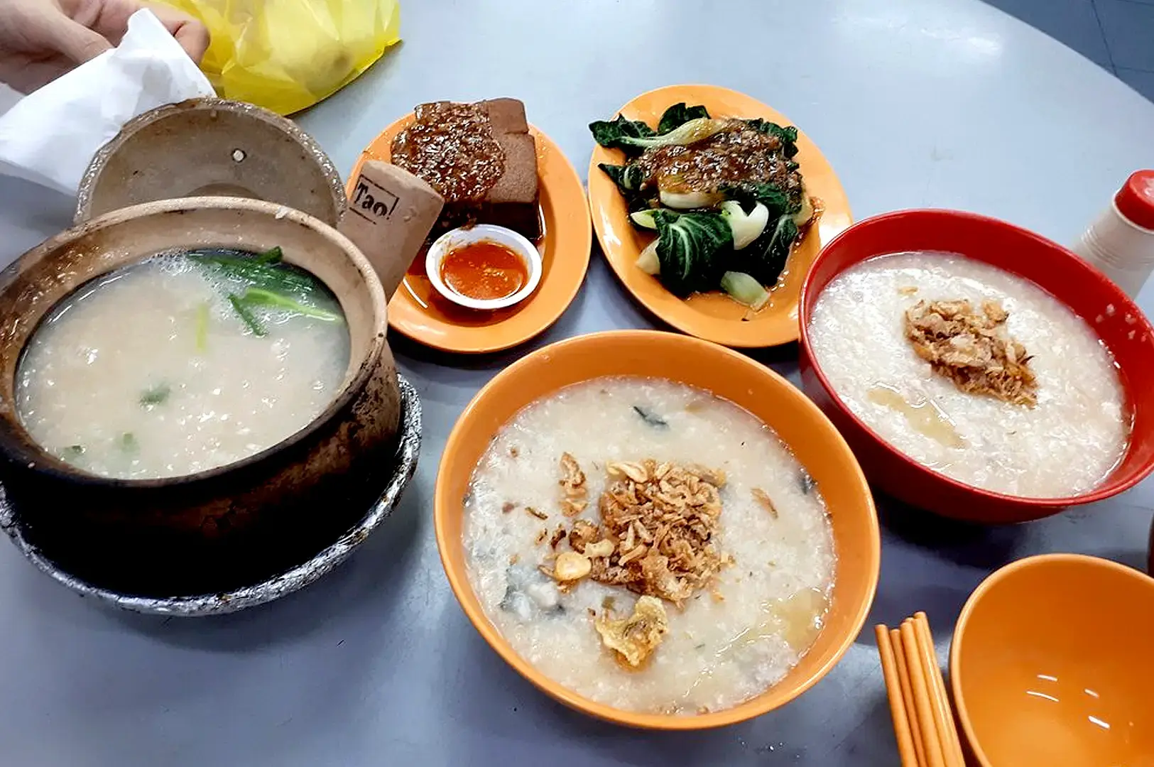 Tiong Shian Porridge Centre Singapore traditional porridge meal with multiple bowls of congee, vegetables and savory side dishes